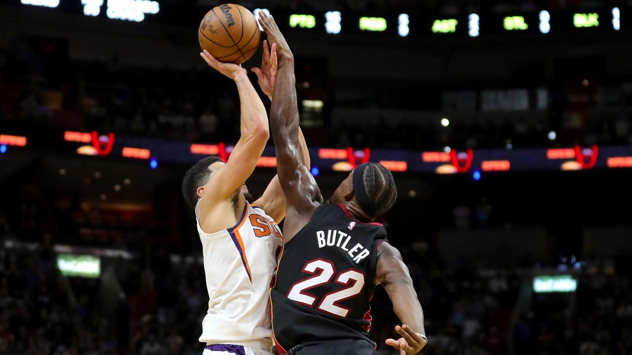 MIAMI, FLORIDA - NOVEMBER 14: Jimmy Butler #22 of the Miami Heat blocks a shot by Devin Booker #1 of the Phoenix Suns during the fourth quarter at FTX Arena on November 14, 2022 in Miami, Florida. NOTE TO USER: User expressly acknowledges and agrees that, by downloading and or using this photograph, User is consenting to the terms and conditions of the Getty Images License Agreement. Megan Briggs/Getty Images/AFP