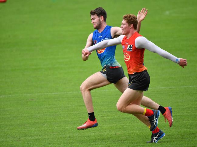 Luke Towey (left) and Matthew Rowell (right) are seen during an AFL Gold Coast Suns training session at Metricon Stadium on the Gold Coast, Thursday, June 18, 2020. (AAP Image/Darren England)