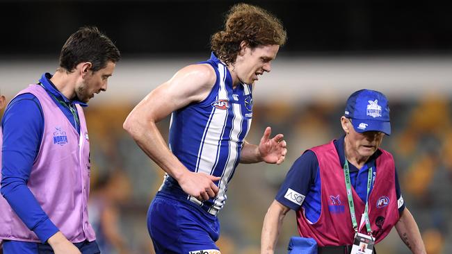 Ben Brown hobbles off with a knee injury in the first quarter against Geelong.