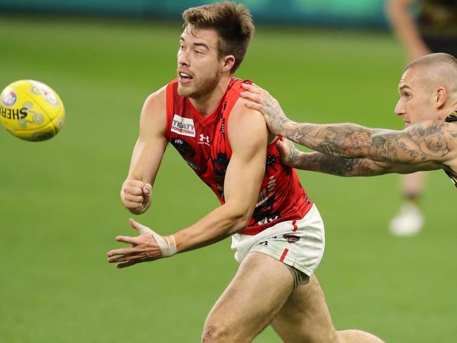 PERTH, AUSTRALIA - JUNE 05: Zach Merrett of the Bombers handpasses the ball under pressure from Dustin Martin of the Tigers during the 2021 AFL Round 12 match between the Essendon Bombers and the Richmond Tigers at Optus Stadium on June 5, 2021 in Perth, Australia. (Photo by Will Russell/AFL Photos via Getty Images)