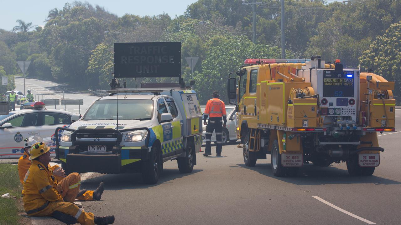 Firefigters take a break from working to contain a bushfire at the southern end of Peregian Beach on the border with Coolum Beach, Queensland, Wednesday, October 23, 2019. The fire started north of the Coolum High school and travelled north towards the beach. (AAP Image/Rob Maccoll) NO ARCHIVING