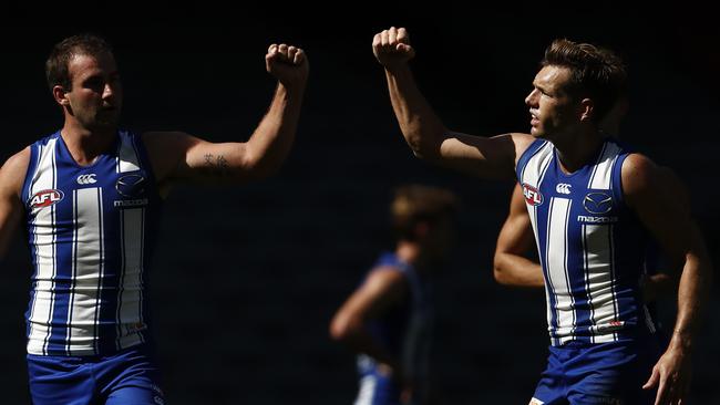 Shaun Higgins (right) celebrates a Kangaroos goal in social distancing style.