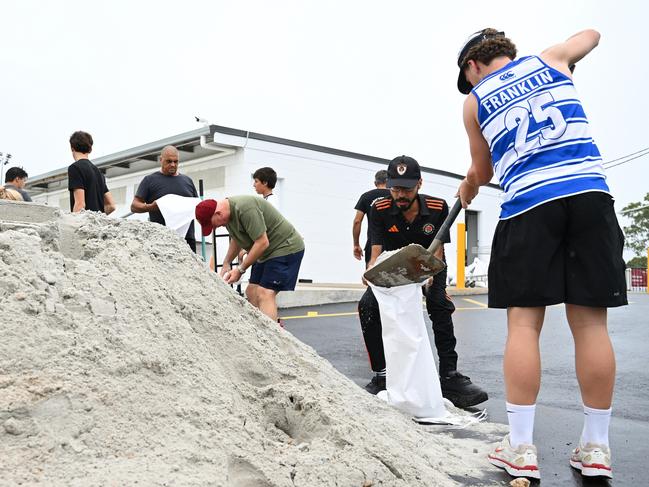 Members of Eastern Suburbs Soccer Club fill sandbags at Heath Park in Brisbane, Australia. Picture: Albert Perez/Getty Images