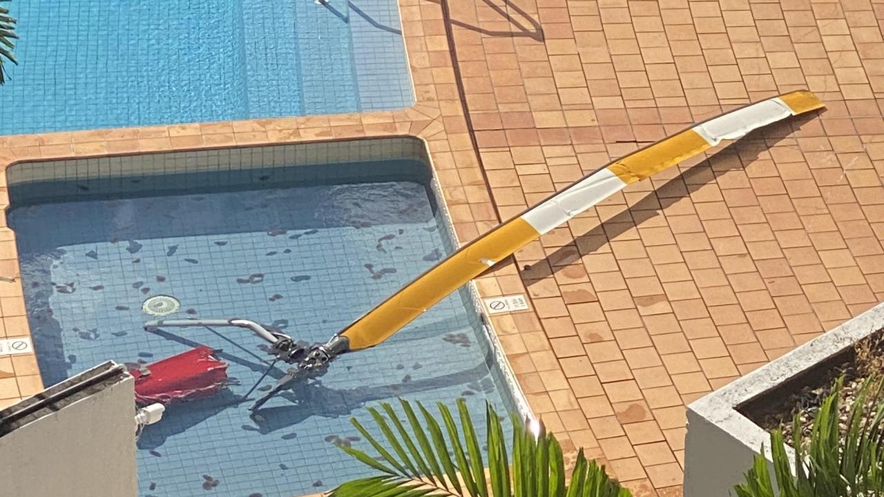 The rotor and part of the tail section of a helicopter lie in the pool of the Double Tree Hilton on the Cairns Esplanade after the aircraft crashed into its roof killing the pilot. Photo: Ian Mullins