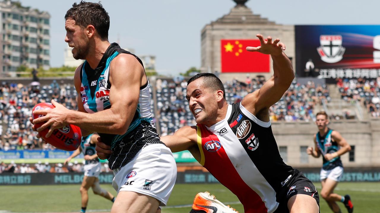 Travis Boak tears away from Shane Savage during last year’s Shanghai match. Picture: AFL Photos