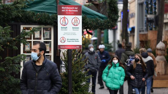 Visitors past a sign that shows 'Visit only to people vaccinated against or recently recovered from Covid-19. Picture: Andreas Rentz