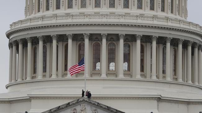 The American flag is lowered to half-staff at the Capitol Building to honour the death of a. Capitol Police Officer who died as a result of injuries sustained in the riots. Picture: Getty Images.