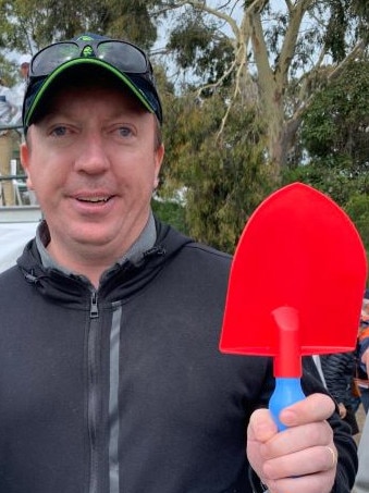 Fan Anthony Roberts with a shovel for Patrick Reed.