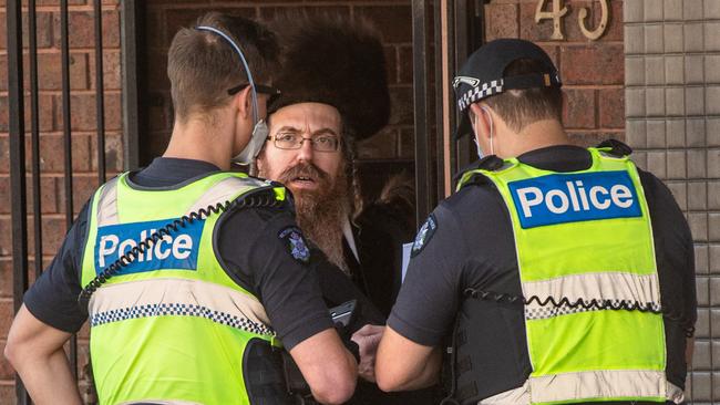 Police speak to a man outside a synagogue in Ripponlea. Picture: Tony Gough