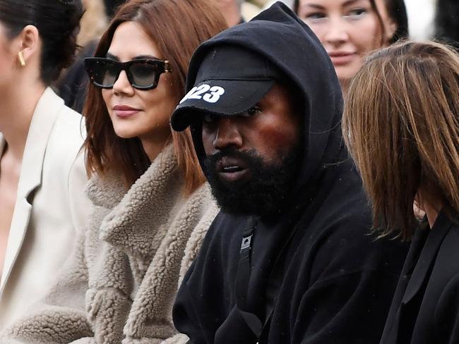 US rapper Kanye West (C), attends the Givenchy Spring-Summer 2023 fashion show during the Paris Womenswear Fashion Week, in Paris, on October 2, 2022. (Photo by JULIEN DE ROSA / AFP)