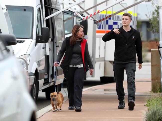 Local council workers collect a dog from the house where the people were found dead in Ellenbrook, Perth. Picture: AAP.