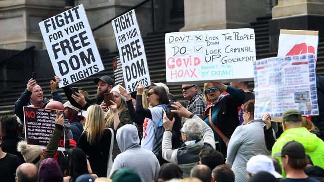 Anti-lockdown protesters hold placards on the steps of Victoria's state parliament in Melbourne. Picture: AFP