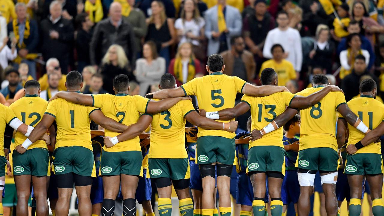 Wallabies players are seen during the Australian national anthem.