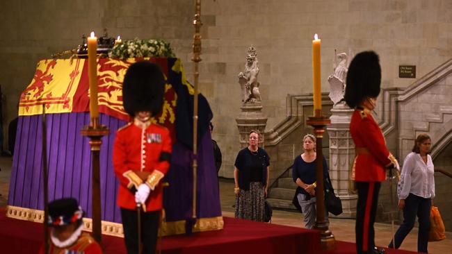 Members of the public file past as soldiers of The Grenadier Guards and Yeomen of the Guard, stand guard around the coffin of Queen Elizabeth II, inside Westminster Hall. Picture: AFP