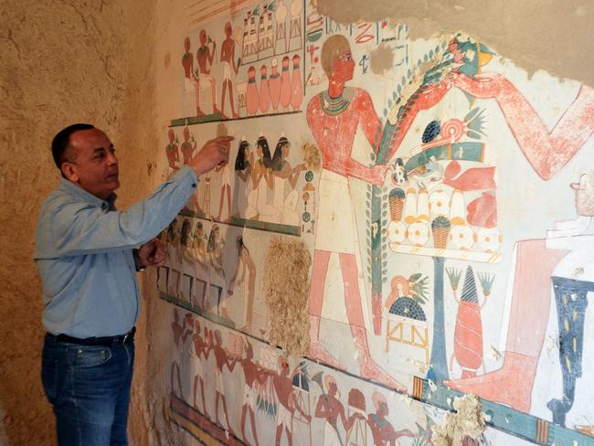 Mustafa al-Waziri, Director General of Luxor's Antiquities, points at an ancient Egyptian mural found at the newly discovered "Kampp 161" tomb at Draa Abul Naga necropolis on the west Nile bank of the southern Egyptian city of Luxor, about 650 kilometres (400 miles) south of the capital Cairo, on December 9, 2017. / AFP PHOTO / STRINGER