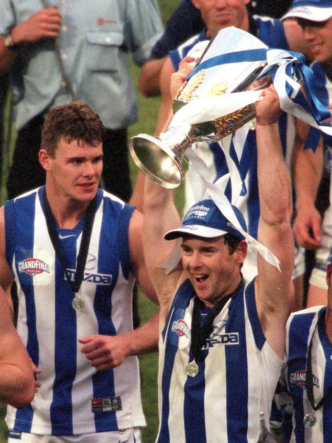 Mooney looks on as Adam Simpson holds the 1999 premiership cup.