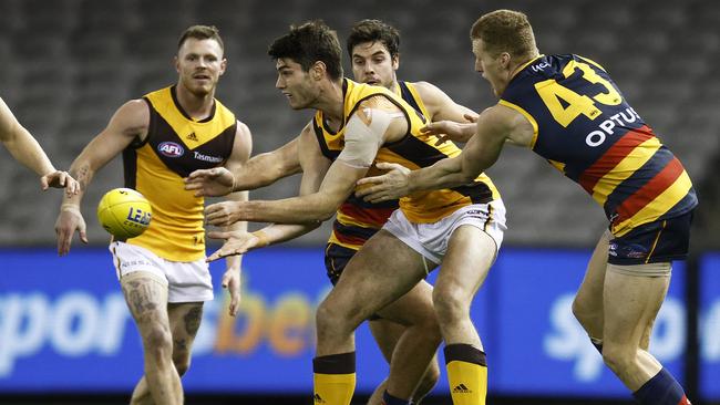 Ned Reeves fires out a handpass in front of Crows Darcy Fogarty and Reilly O’Brien. Picture: Daniel Pockett/Getty Images