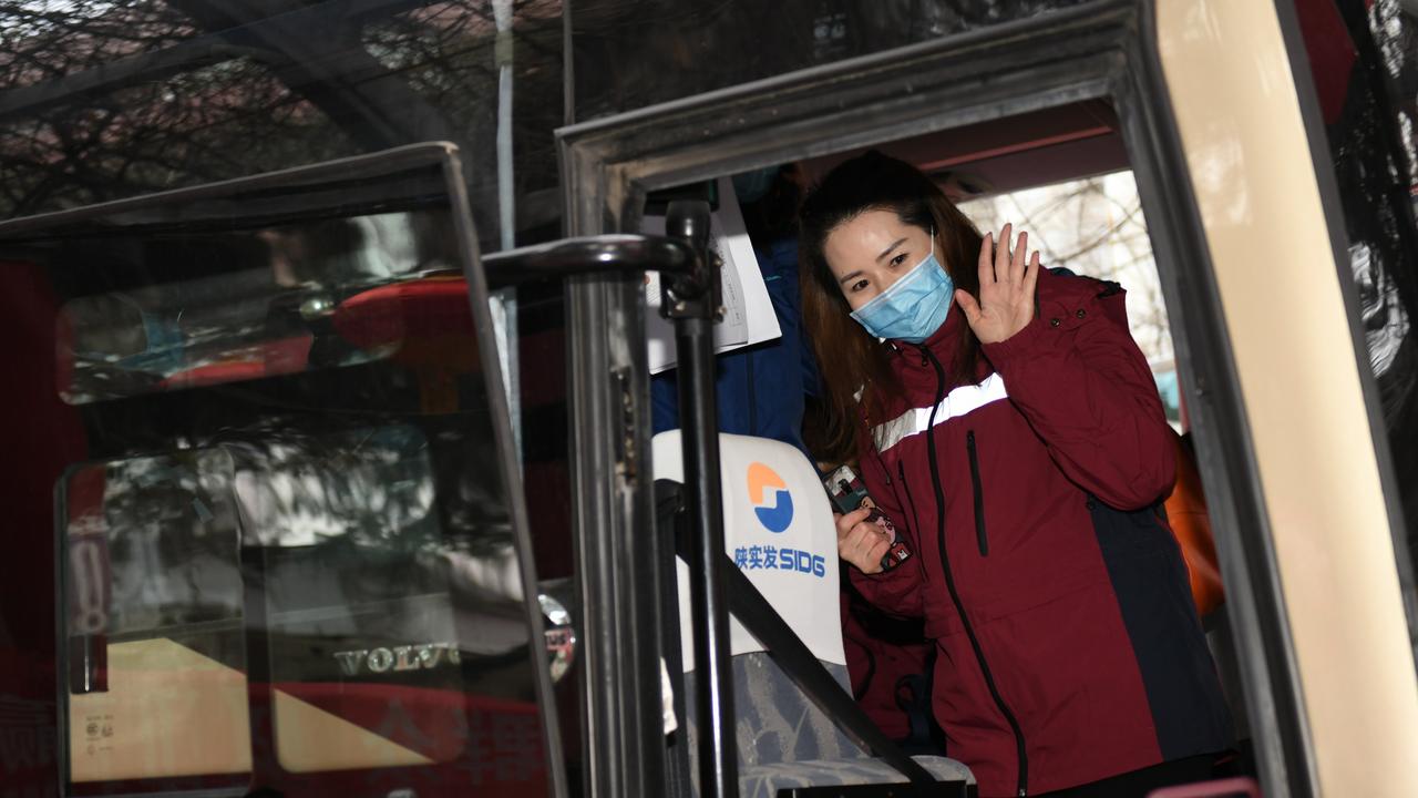 A medical worker waves goodbye in Xian for the 750km journey to the Wuhan epicentre. Picture: Xinhua/Li Yibo