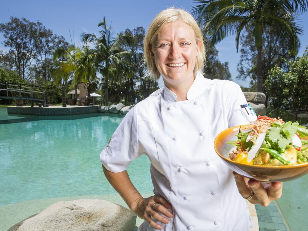 Executive chef Lisa Mahar by the pool holding a sticky rice Vietnamese yellow curry with crispy skin roasted chicken, fresh coconut and an Asian herb salad. Picture: Lachie Millard