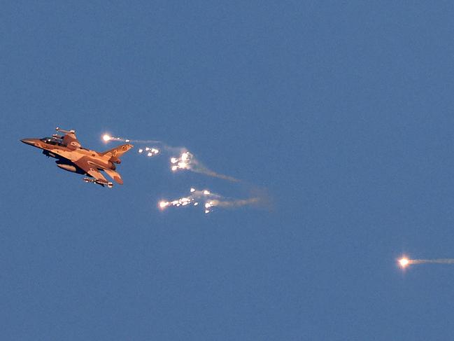 This photo taken from a position in northern Israel shows an Israeli Air Force fighter jet firing flares as it flies to intercept a hostile aircraft that launched from Lebanon over the border area with south Lebanon on August 25. Picture: Jalaa Marey/AFP