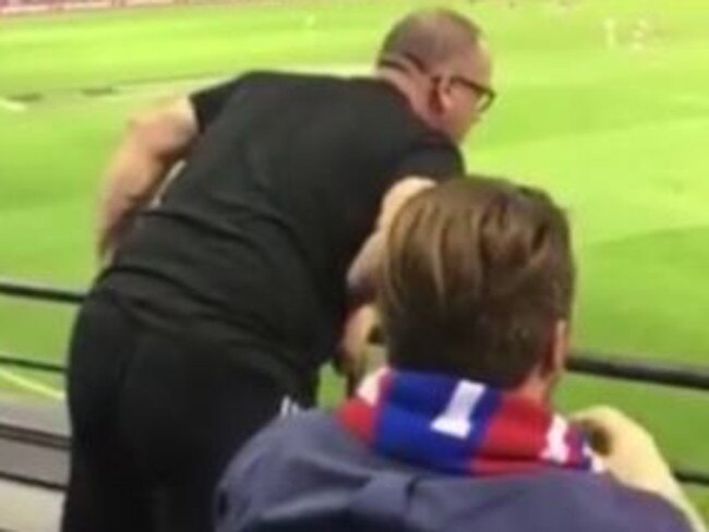 An AFL fan is filmed allegedly hurling racial abuse at a trainer