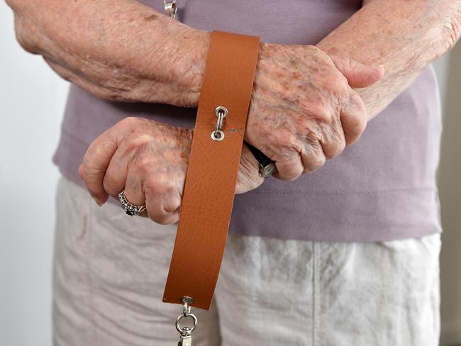 Victim of forced adoption Jan Benson with the strap used to restrain her to the bed. Picture: Patrick Woods.