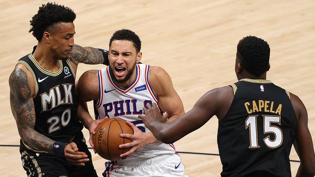 ATLANTA, GEORGIA - JUNE 18: Ben Simmons #25 of the Philadelphia 76ers drives between John Collins #20 and Clint Capela #15 of the Atlanta Hawks during the first half of game 6 of the Eastern Conference semi-finals at State Farm Arena on June 18, 2021 in Atlanta, Georgia. NOTE TO USER: User expressly acknowledges and agrees that, by downloading and or using this photograph, User is consenting to the terms and conditions of the Getty Images License Agreement. (Photo by Kevin C. Cox/Getty Images)