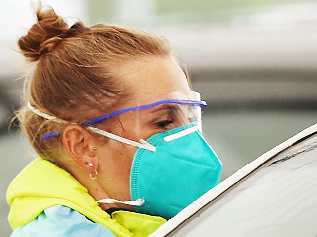 SYDNEY, AUSTRALIA - MAY 06: A nurse collects COVID-19 test samples at the Bondi drive-through testing clinic on May 06, 2021 in Sydney, Australia. Two new locally acquired COVID-19 cases have been recorded in NSW after a man who lives in Sydney's Eastern Suburbs tested positive for coronavirus on Wednesday. NSW Health is urgently investigating the source of infection of the mystery case, as the man has not returned from overseas or has any links to hotel quarantine. The positive cases visited a number of venues across Sydney while infectious, with people urged to isolate and get tested if they visited venues of concern. COVID-19 restrictions have been tightened across Greater Sydney in response to the new cases. From midday Thursday masks will be compulsory on public transport and in all public indoor venues such as retail, theatres, hospitals and aged care facilities; visitors to households will be limited to 20 guests including children; visitors to aged care facilities will be limited to two people, singing and dancing not permitted at indoor venues.  (Photo by Mark Metcalfe/Getty Images)