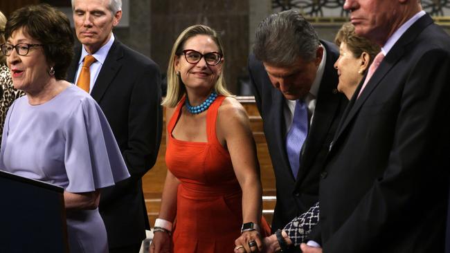 Kyrsten Sinema, centre, shares a moment with fellow Democrat senator Jeanne Shaheen as Susan Collins addresses the media on Thursday. Picture: AFP
