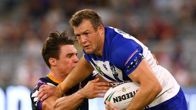 PERTH, AUSTRALIA — MARCH 10: Josh Morris of the Bulldogs fends off a tackle during the round one NRL match between the Canterbury Bulldogs and the Melbourne Storm at Optus Stadium on March 10, 2018 in Perth, Australia. (Photo by Paul Kane/Getty Images)