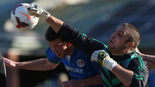 Mudgeeraba goalkeeper Tim Warren (right) punches the ball away. Picture: Regi Varghese