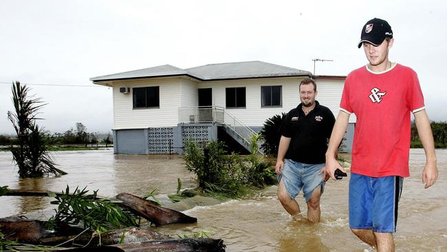 Clayton (R) and Matthew Hoy wade through flood waters surrounding their family home outside Innisfail, 84 kilometres from Cairns, which was destroyed by Cyclone Larry in 2006. (AP Photo/Rob Griffith)