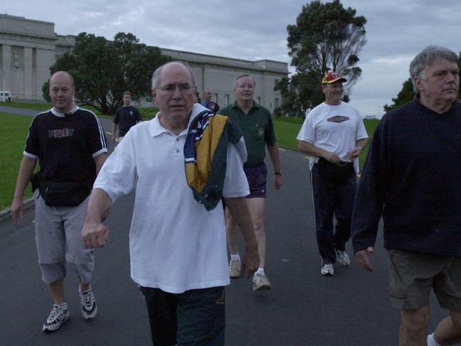 Former prime minister John Howard was famed for his morning walking routine, even when overseas, here pictured with an Australian tracksuit and security detail in Auckland, New Zealand.