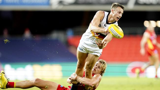 Tom Doedee gets a handball away under pressure from old teammate Hugh Greenwood. Picture: Dave Hunt (AAP).