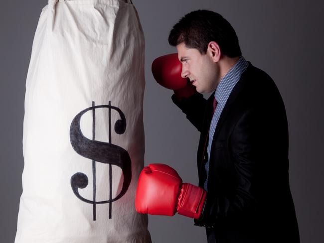 Businessman punching money bag with boxing gloves; dollar sign money generic