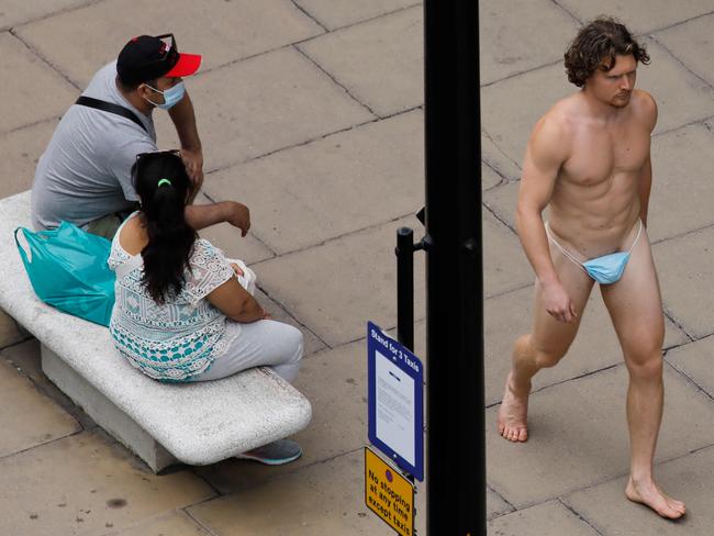 TOPSHOT - A man wearing a face mask to cover his genitals is seen walking along Oxford Street in London on July 24, 2020, after wearing facemasks in shops and supermarkets became compulsory in England as a measure to combat the spread of the novel coronavirus. (Photo by Tolga AKMEN / AFP)