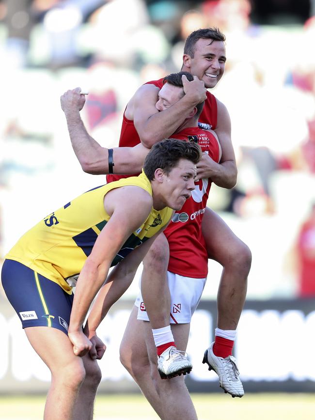 Cameron Craig and Jake Wohling celebrate North’s win on the siren as Eagle Jack Hayes slumps in despair. Picture SARAH REED