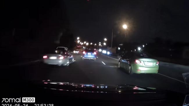 The black sedan can be seen speeding through the lane as the white hatchback indicates to exit. Picture: Supplied / Dash Cam Owners Australia