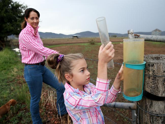 Felicity Mammen, 7, checks the rain gauge with mum Janice Mammen on the family's farm in north west NSW, Saturady, February 8, 2020. The Mammen family have had 70mm of rain this year so far. (AAP Image/Peter Lorimer) NO ARCHVING