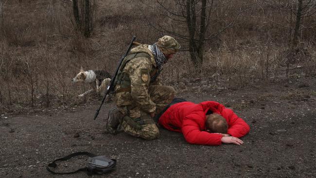 A Ukrainian serviceman checks on a man who was acting suspicious not far from the positions of Ukraine's service members. Picture: AFP