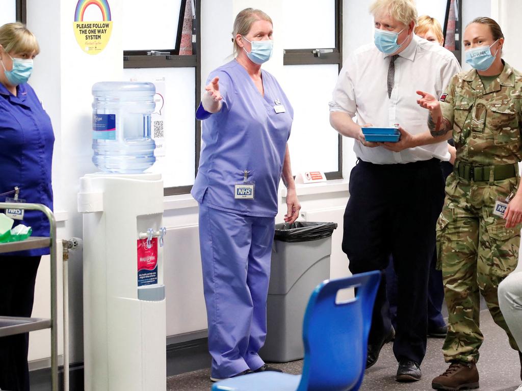 Britain's Prime Minister Boris Johnson walks with corporal Lorna MacDonald during a visit to a vaccination centre in Northampton, as the UK announces big changes to its entry rules. Picture: AFP