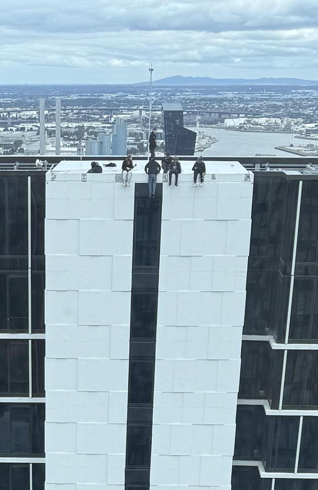 Another image posted on the same day showed what appeared to be seven people sitting and dangling off the edge of a highrise.