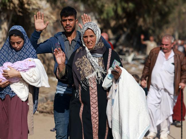 Palestinians fleeing Gaza City and other parts of northern Gaza, raise their arms as they walk along a road leading to the southern areas of the enclave. Picture: AFP