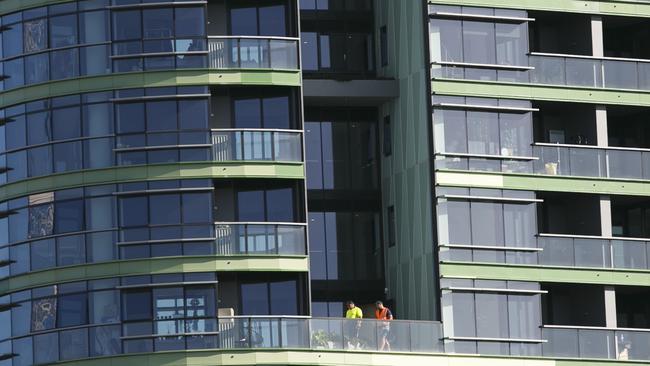 Workers inspect the building. Picture: Tim Pascoe