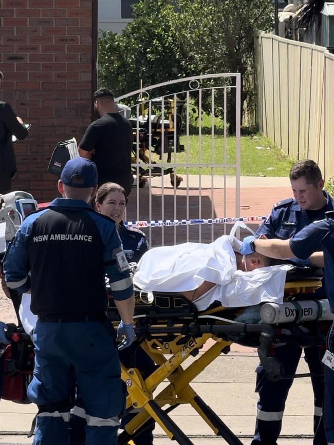 Paramedics rush one of the men to hospital after the alleged stabbing.