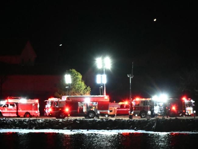 Emergency vehicles and rescue crews gather along the Potomac River near Reagan National Airport after an air crash near Washington, DC, on January 29, 2025. A regional jet from Kansas crashed into Washington's Potomac River after colliding mid-air with a military helicopter near Reagan National Airport, officials said Wednesday, prompting a major emergency response and grounding all flights. (Photo by ANDREW CABALLERO-REYNOLDS / AFP)