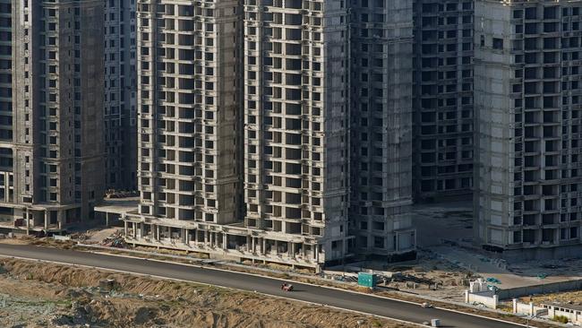 A vehicle travels past some of the 39 buildings developed by China Evergrande Group that authorities have issued a demolition order on. Picture: Aly Song/Reuters