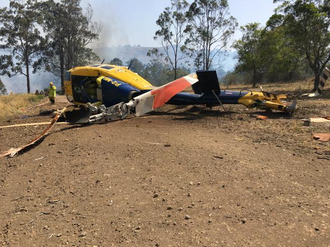 The water-bombing helicopter lies on its side after crash-landing.