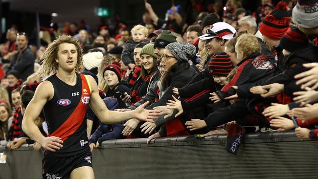 Essendon captain Dyson Heppell celebrates a win with fans.