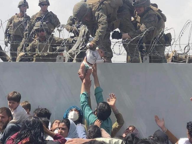 A US marine lifts a baby over a barbed-wire fence during an evacuation at Hamid Karzai International Airport in Kabul. Picture: Omar Haidiri/AFP